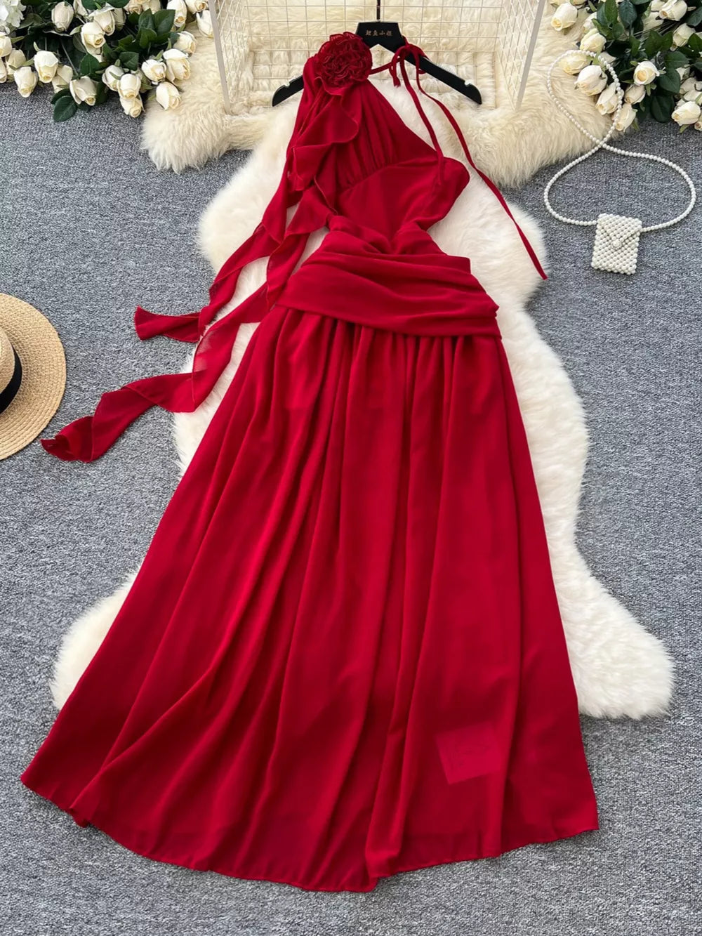 Red floral accent one-shoulder maxi dress with flowing skirt and tie details.