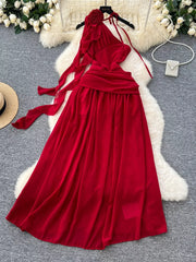Red floral accent one-shoulder maxi dress with flowing skirt and tie details.
