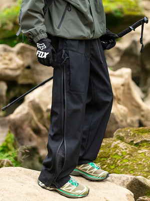 Black utility-inspired wide-leg sweatpants with zippered side vents and mesh detailing.
