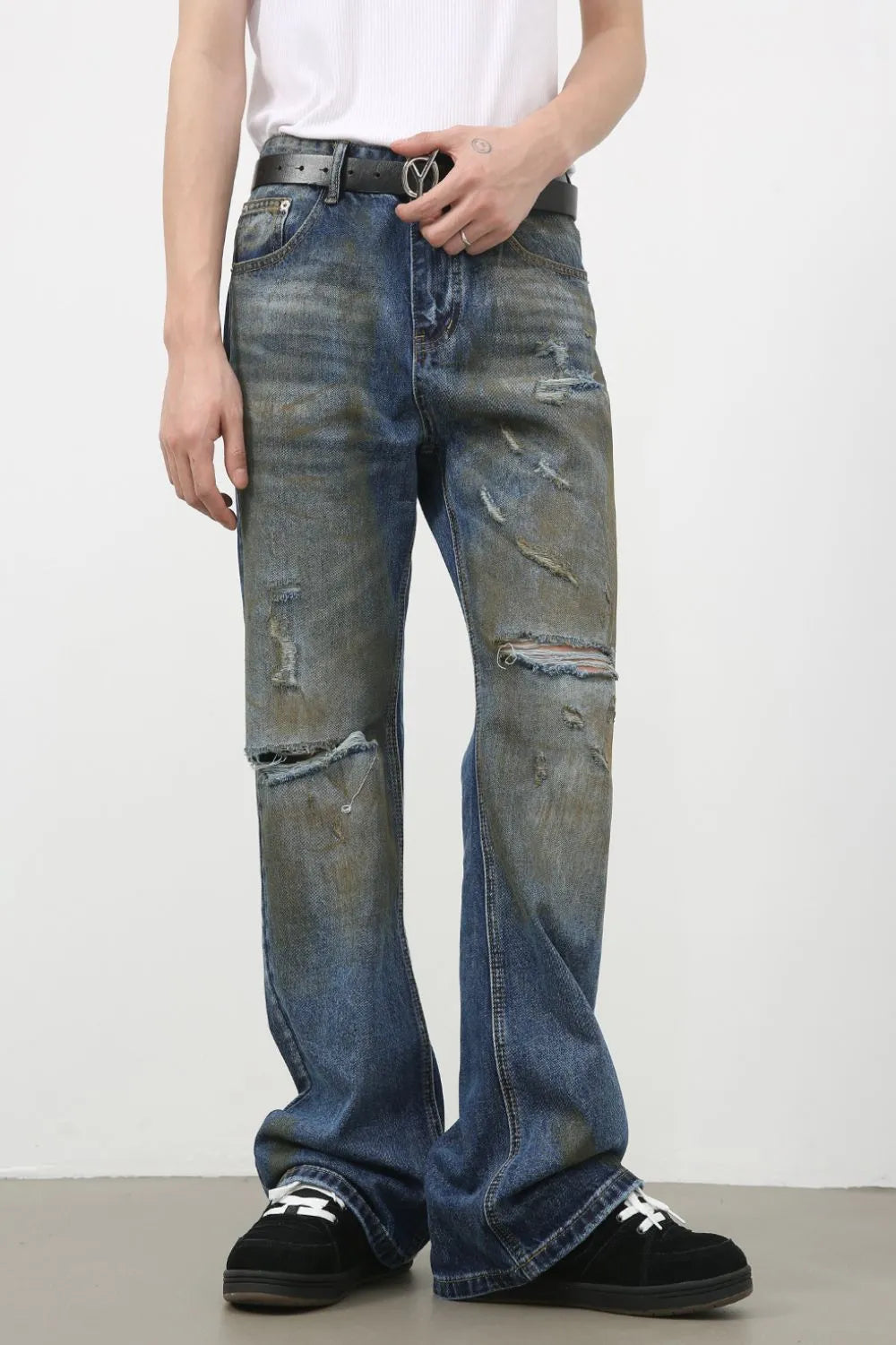 Distressed flare jeans in medium wash denim with patina and ripped details.