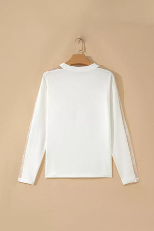 White long sleeve crew neck shirt with delicate lace details on the sleeves.