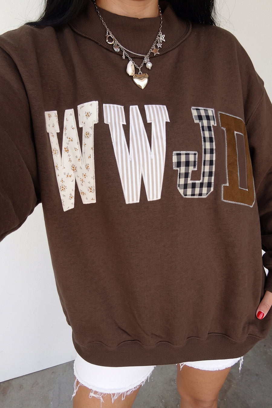 white sweatshirt featuring embroidered patch and mixed pattern, graphic, gingham, striped, ditsy floral