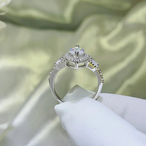 White moissanite engagement ring with marquise center stone and baguette side stones.