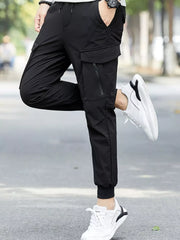Black cargo joggers with zippered pockets and drawstring waist, styled with white sneakers.