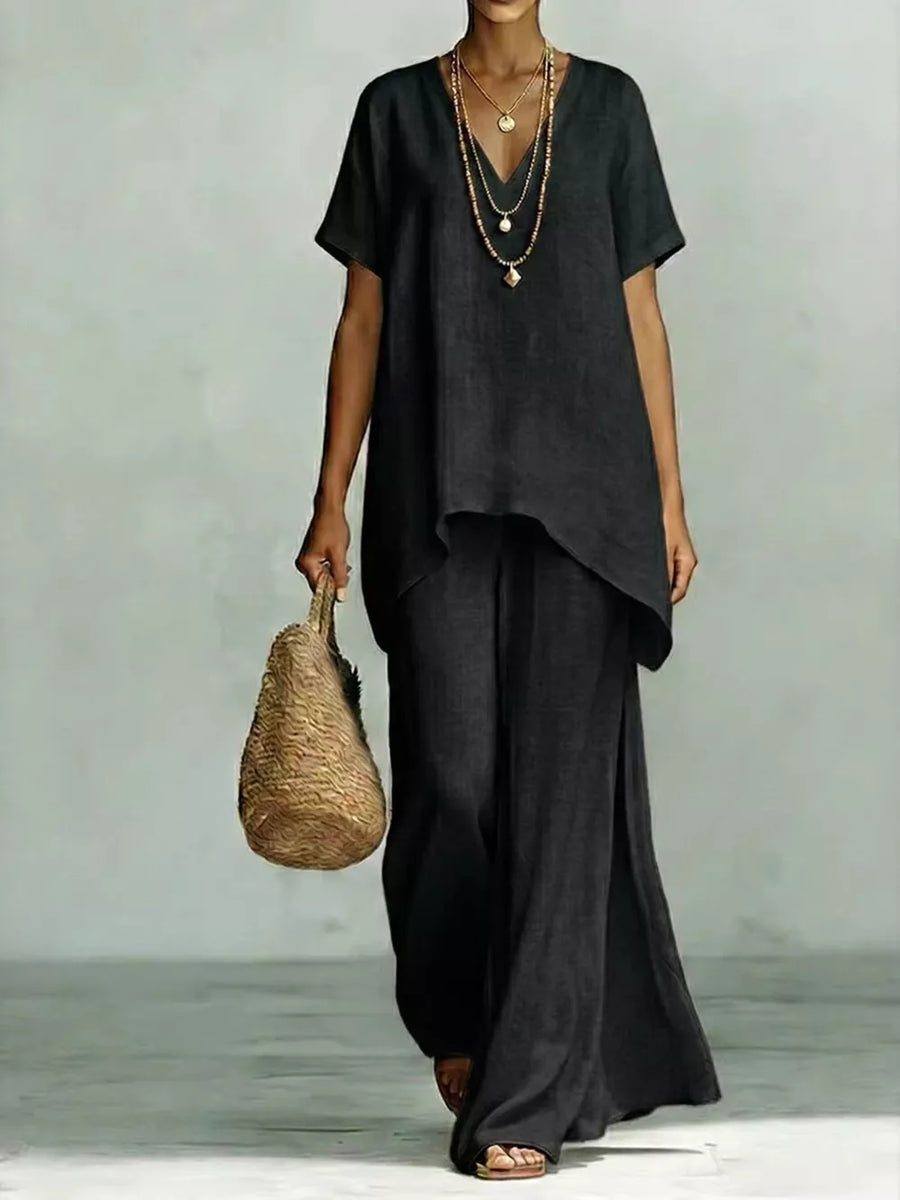 Black linen v-neck short sleeve tunic with wide leg pants and layered necklaces.