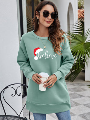 Sage green tunic sweatshirt with Santa hat and "Believe" graphic, crew neck, long sleeves.