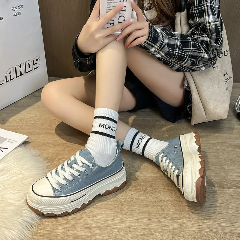 Light blue canvas tread sneakers with white laces and thick platform sole.