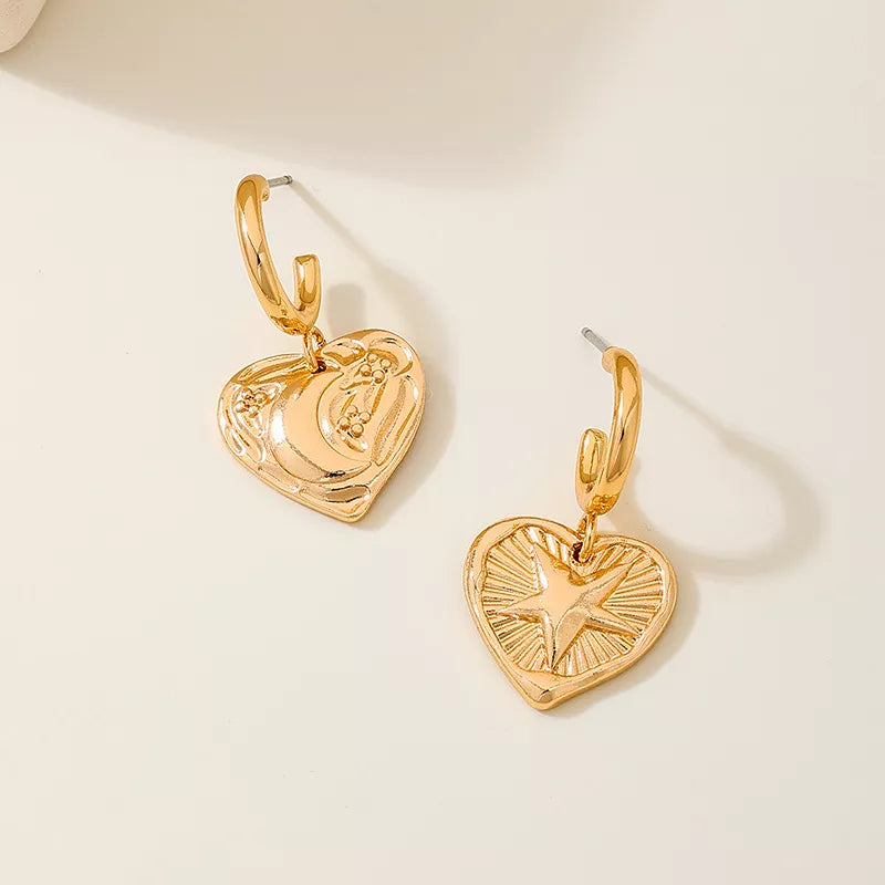 Golden earrings featuring heart-shaped and geometric