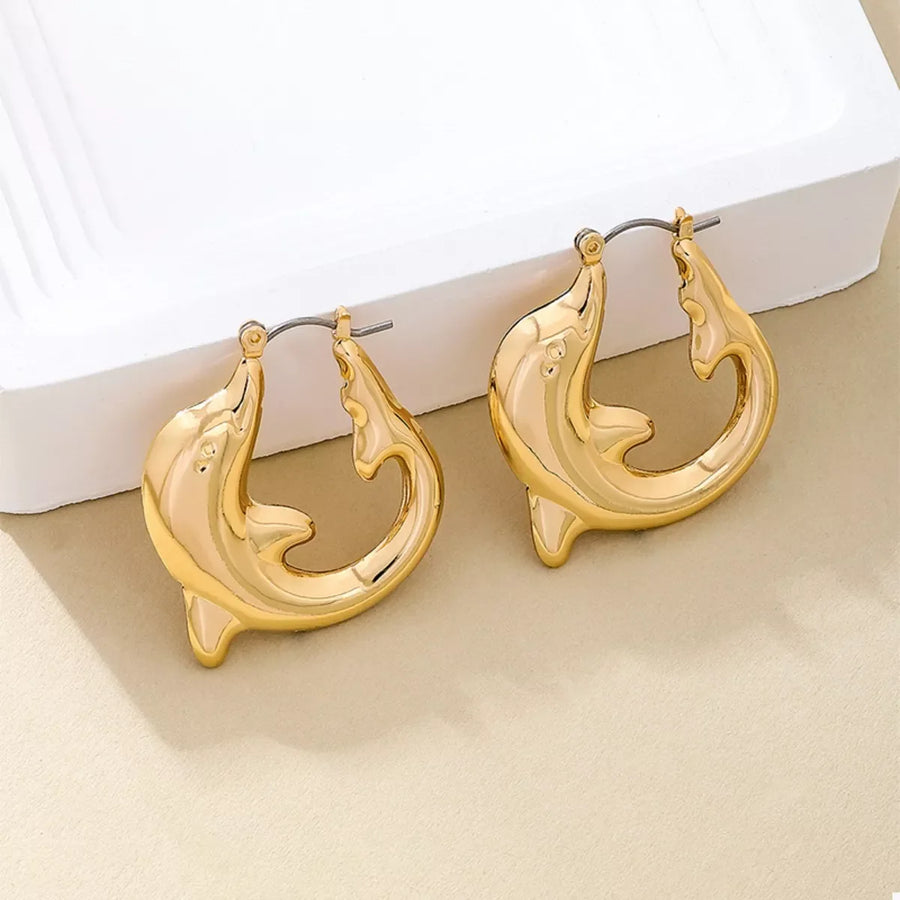 Gold dolphin hoop earrings with a sleek, polished finish.