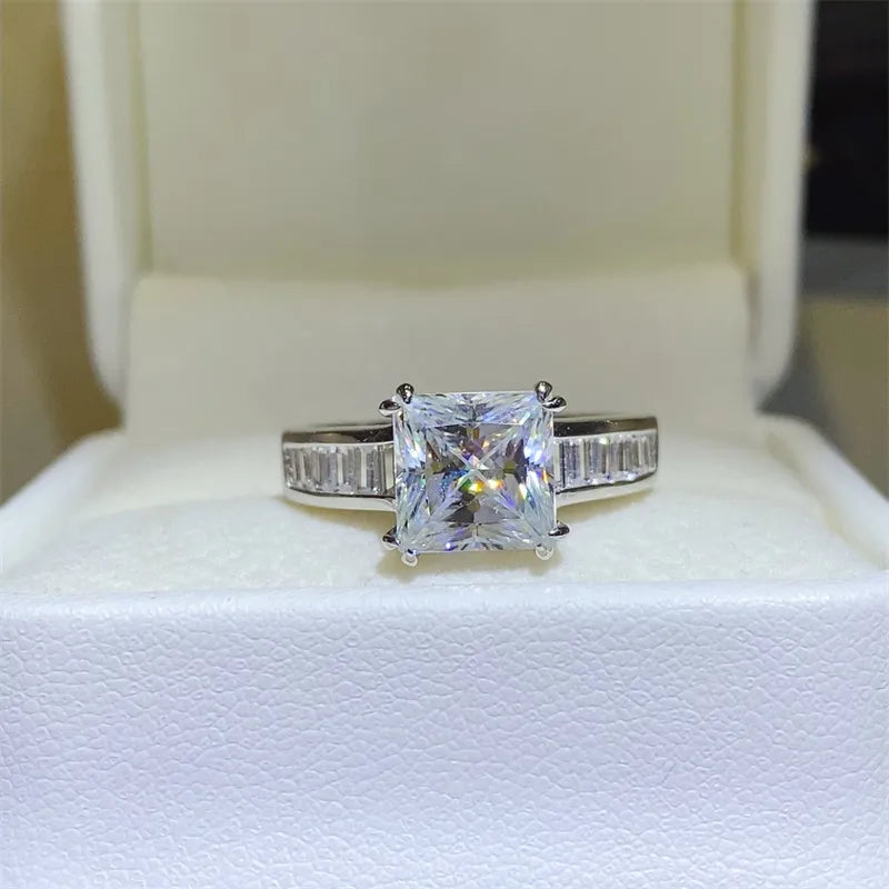Princess cut diamond ring in silver with baguette band detail.