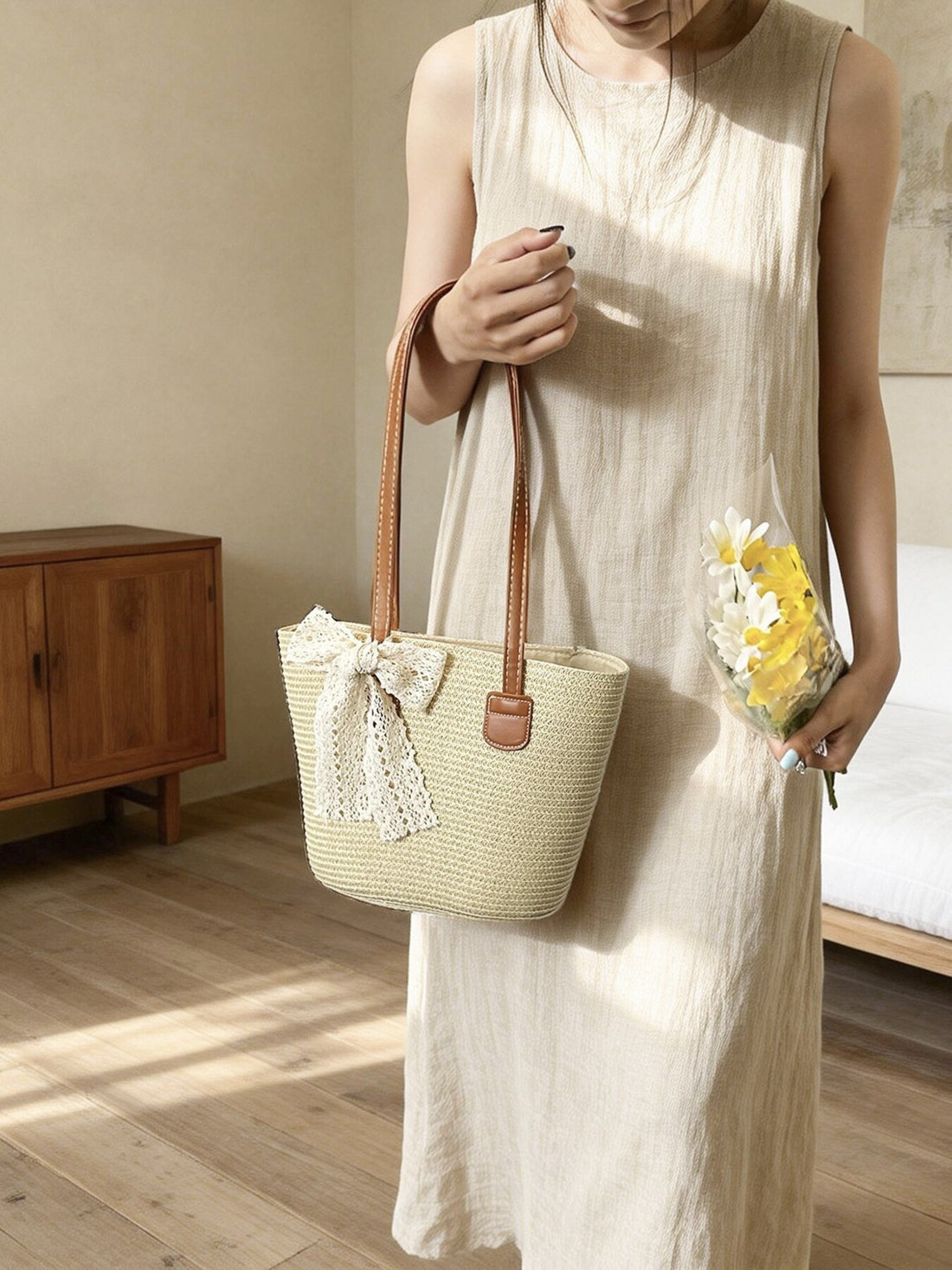 Charming straw shoulder bag in off-white with lace bow detail and leather handles.