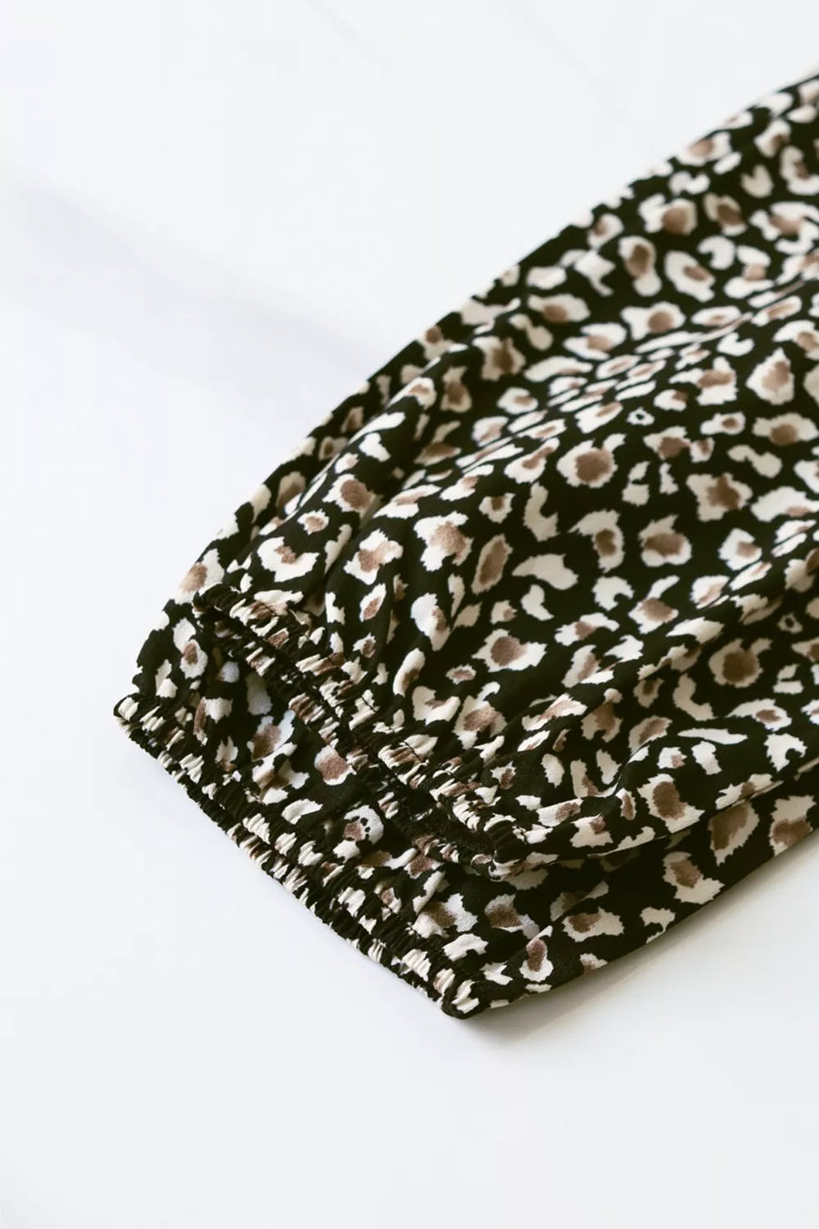 Chic midi dress with balloon sleeves in black animal print, featuring elasticated cuffs.