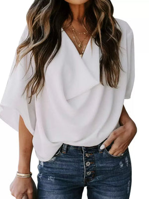 White flowy half sleeve blouse with draped neckline, styled with jeans.