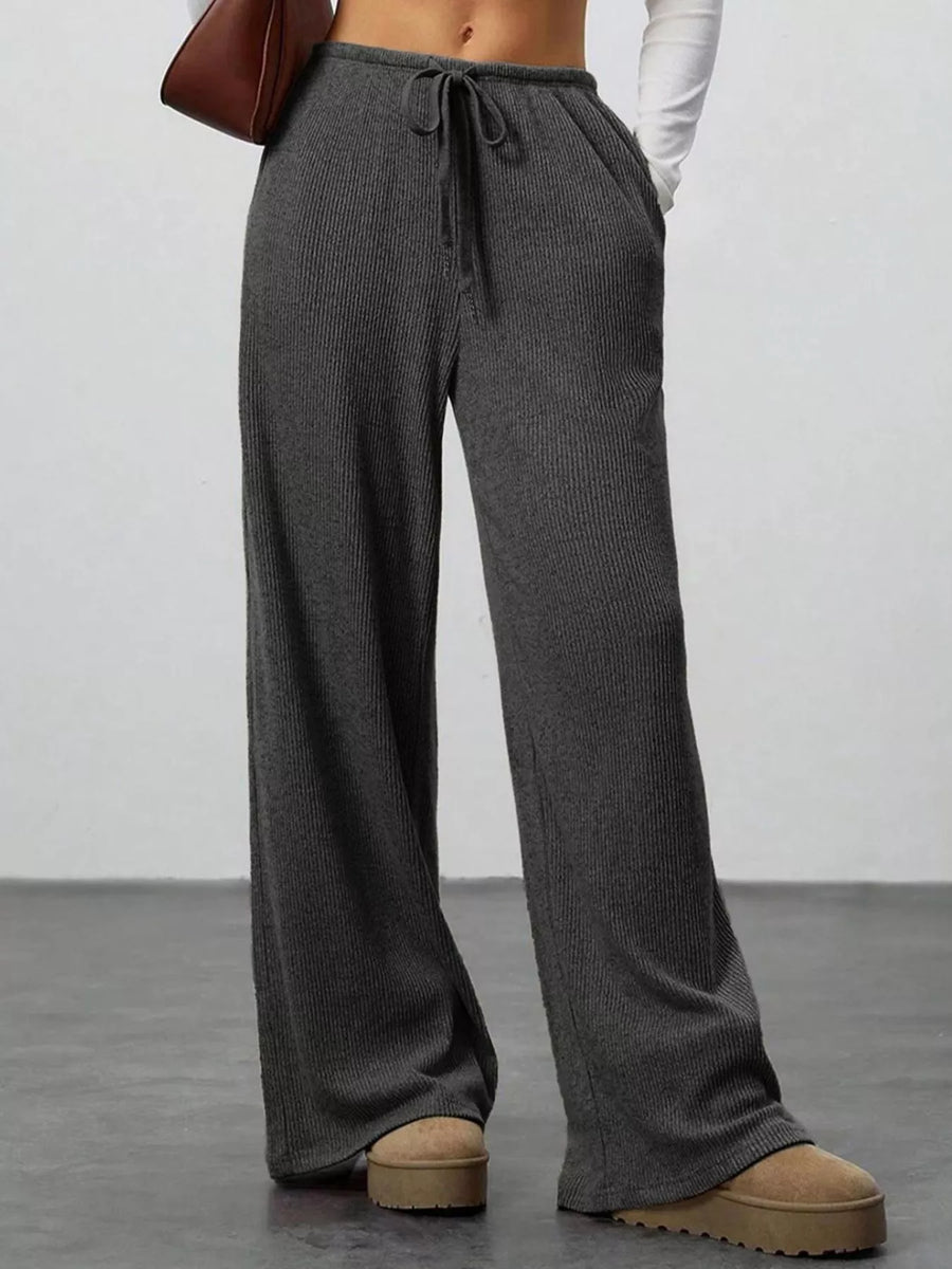 Dark gray ribbed wide-leg pants with drawstring waist and pockets.