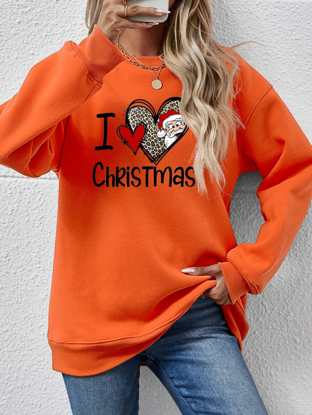 Orange crewneck sweatshirt with festive heart graphic and Santa Claus detail.
