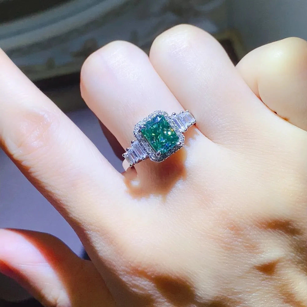 Emerald-cut moissanite halo ring in silver with baguette side stones.