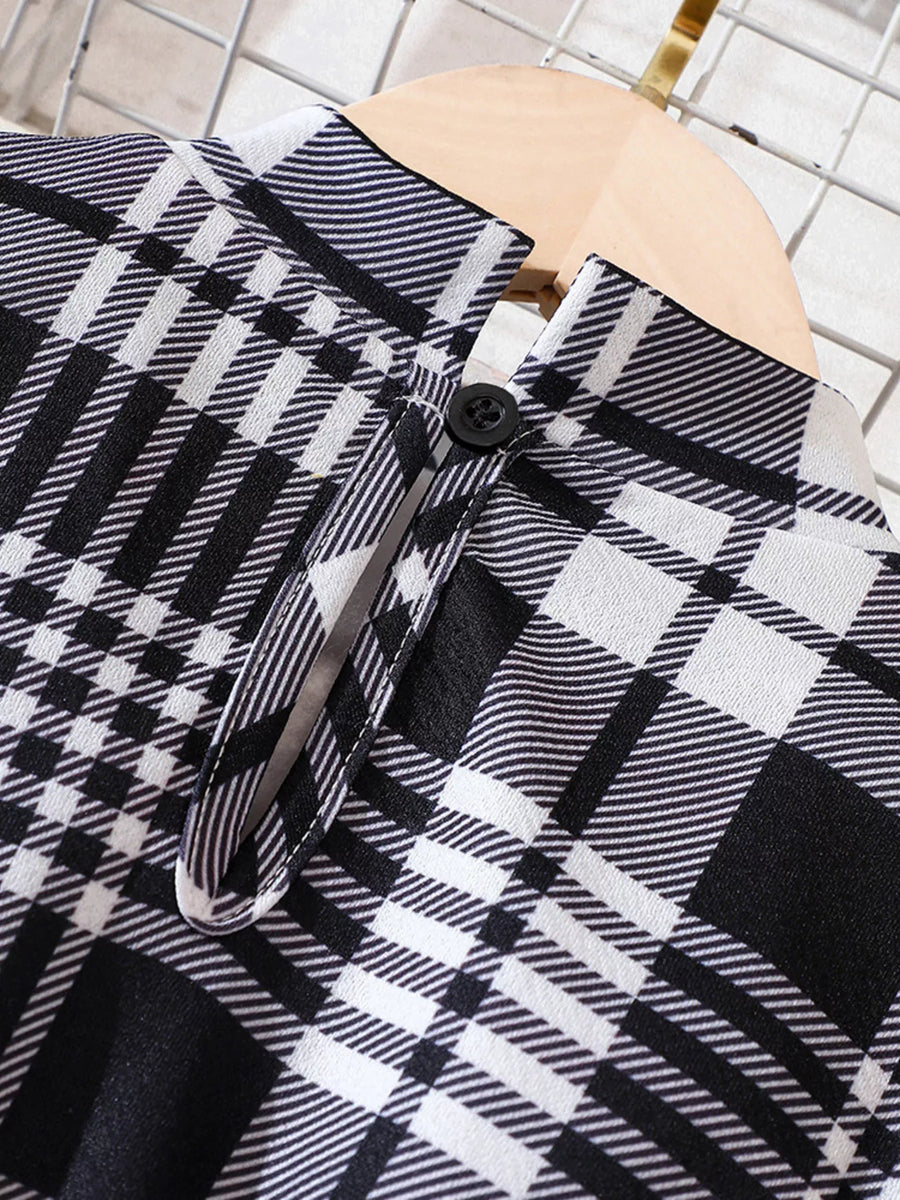 Belted plaid long-sleeve dress in black and white with a button detail.