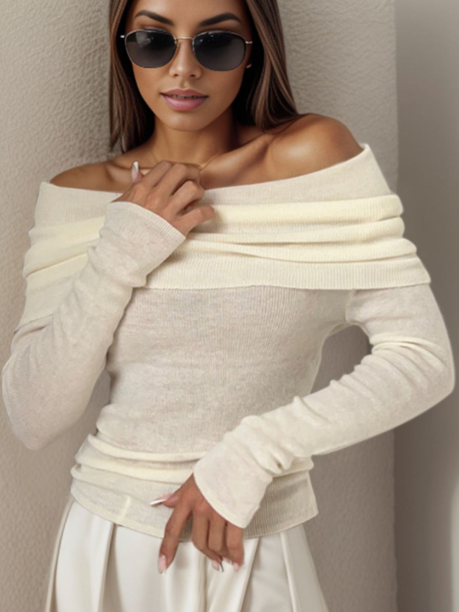 Ivory knit sweater with off-the-shoulder neckline and long sleeves.