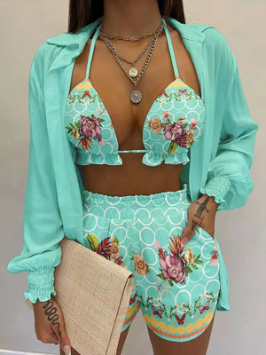Mint blue floral print two-piece outfit set with frill trim bikini top and shorts, worn with a matching sheer shirt.
