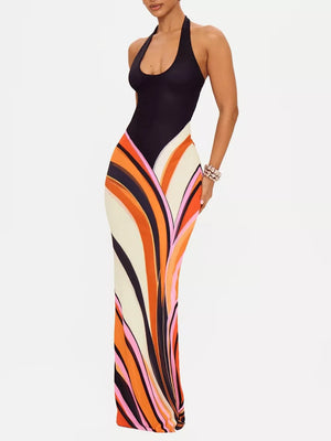 Maxi dress with halter neck and bold wavy stripe print in black, cream, orange, and pink.