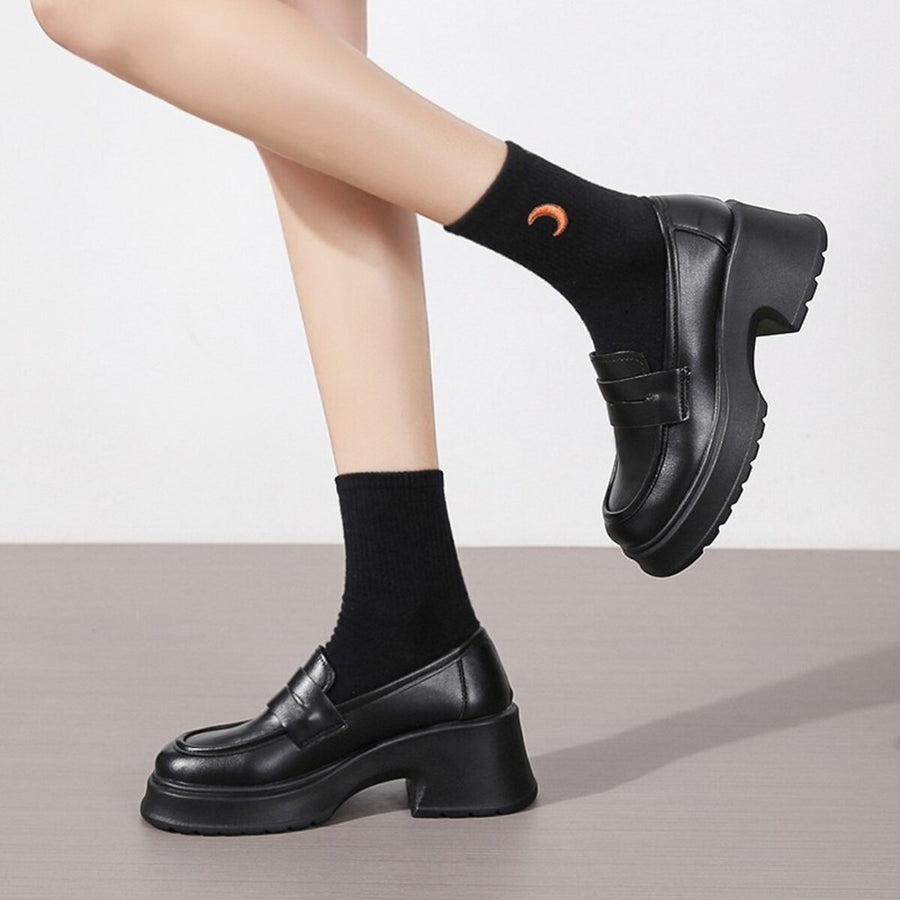 Black leather round toe block heel loafers with chunky sole and strap detail.