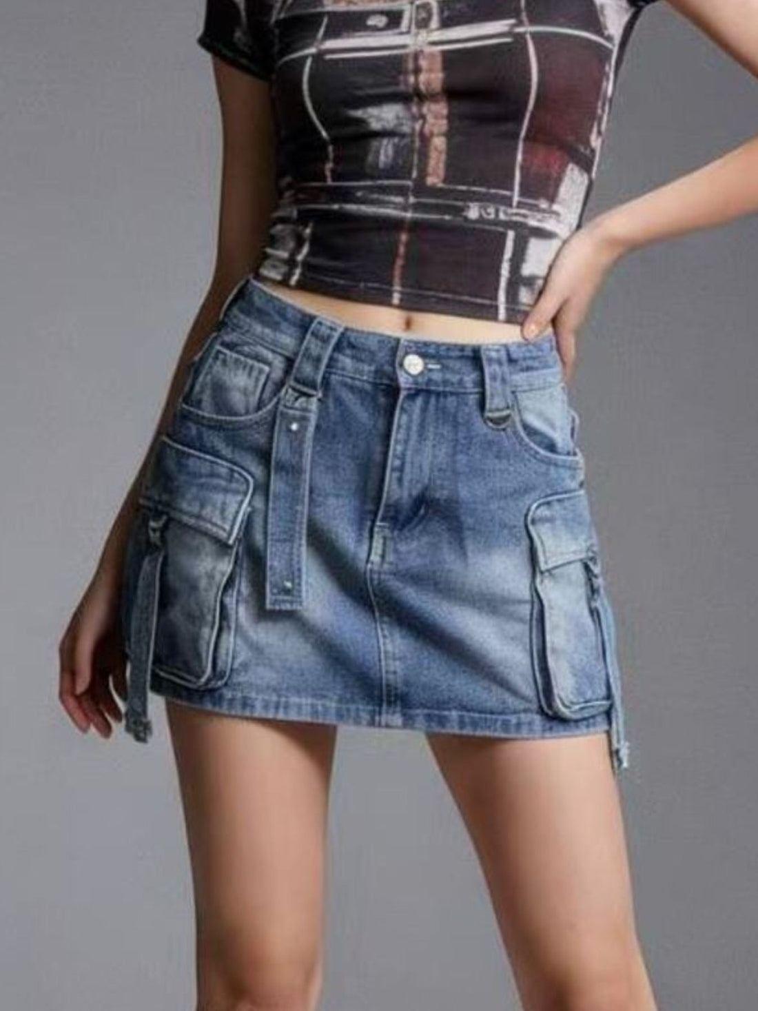 Plus size dark blue washed denim cargo skirt with button closure and utility pockets.