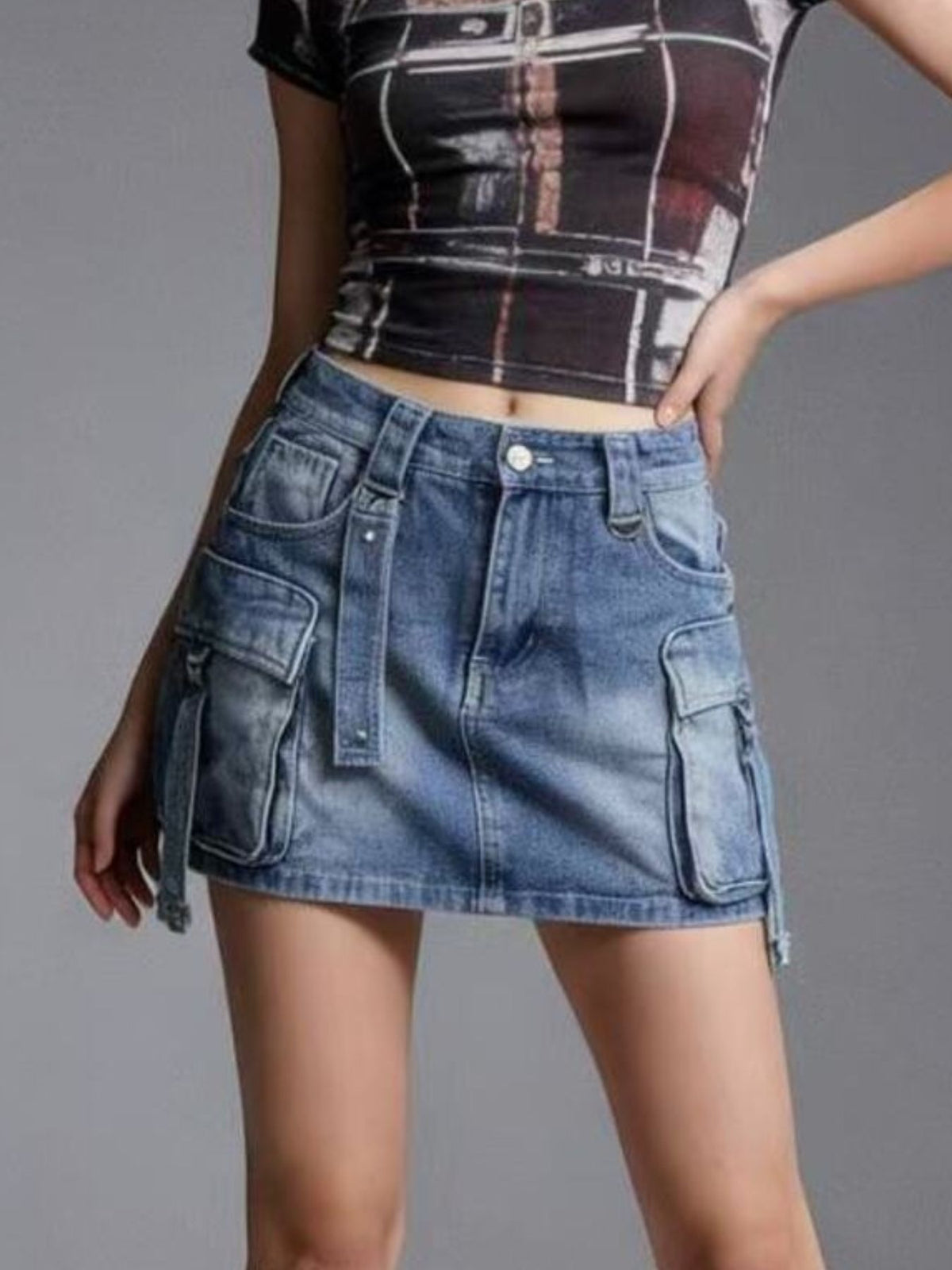 Plus size dark blue washed denim cargo skirt with button closure and utility pockets.