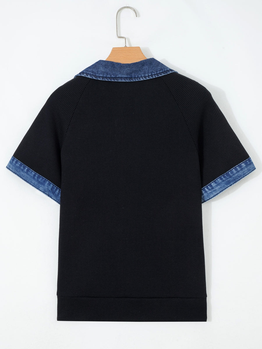 Black textured knit polo top with short sleeves and denim collar and cuffs.
