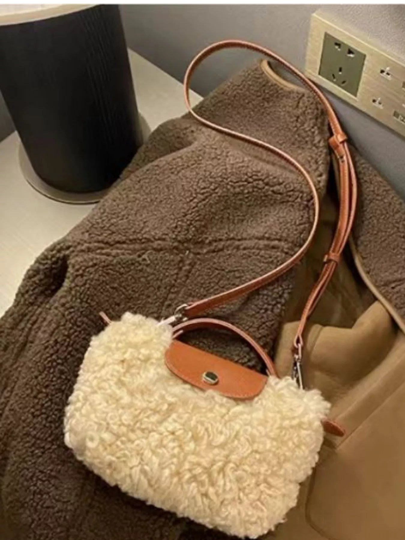 Textured mini crossbody bag in cream fuzzy material with brown leather trim and strap.