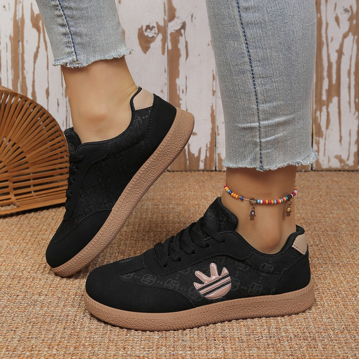 Black lace up sneakers with all over pattern and tan sole.