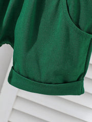 Dark green cotton baby shorts with cuffed hem and pocket detail.