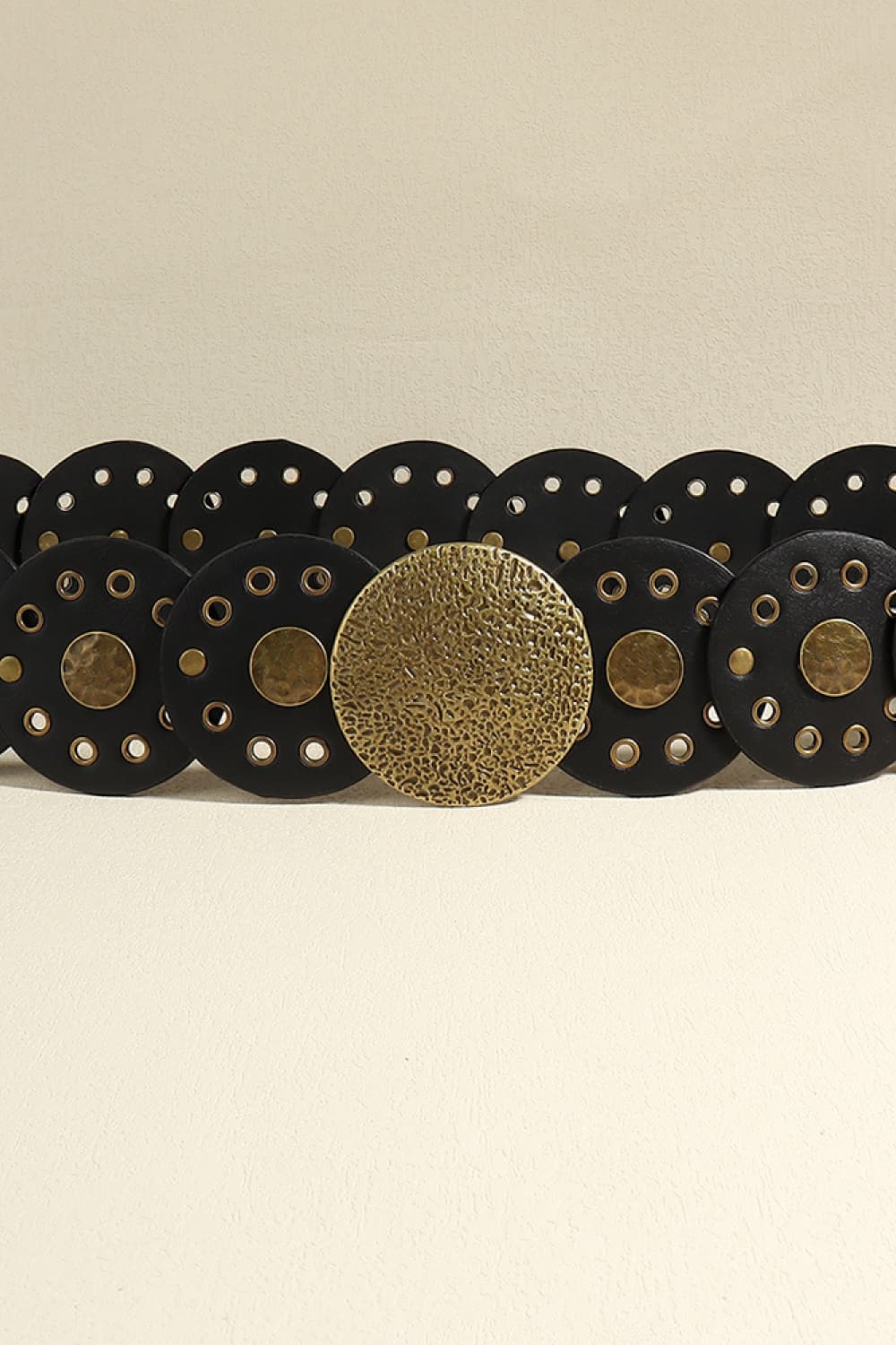 Black faux leather belt with round disc embellishments and gold-tone hardware.