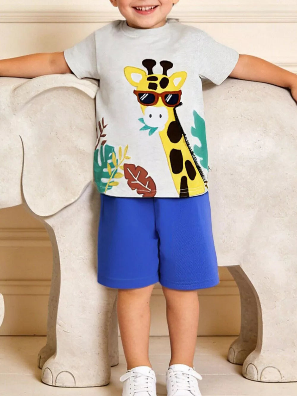 Toddler boys' grey graphic t-shirt with a playful giraffe wearing sunglasses, paired with blue cotton shorts.