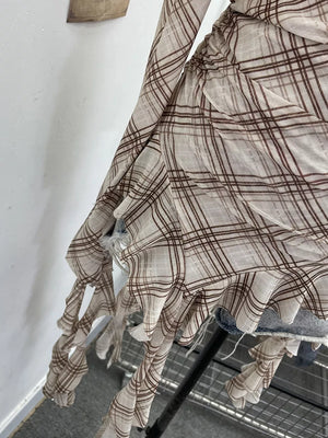 Taupe plaid asymmetrical ruffle hem t-shirt with distressed details.