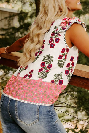 Vibrant floral cotton blouse with ruffled sleeves and contrast trim, featuring red flowers and a pink floral border.