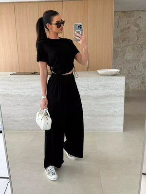 Black crop top and wide-leg pants set with adjustable drawstring details.