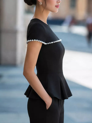 Black peplum t-shirt with pearl trim on sleeves and neckline.