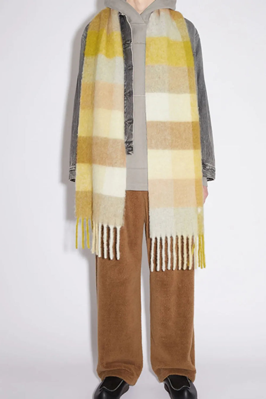 Checked plaid winter wrap scarf in yellow and brown with fringe details.
