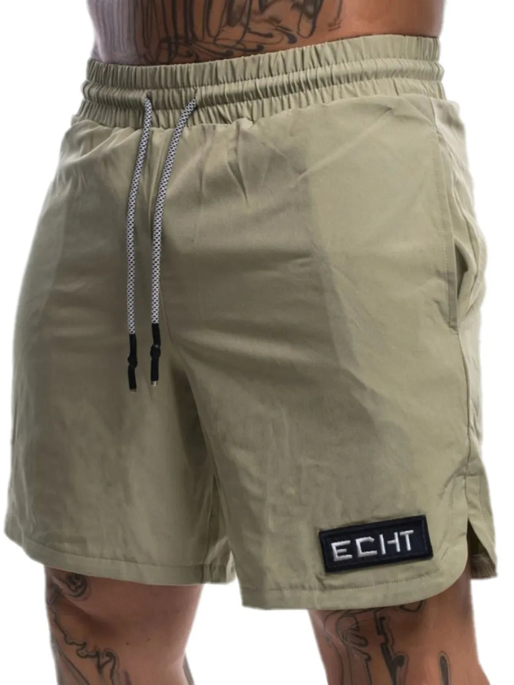 Khaki performance drawstring shorts with logo patch and side vents.