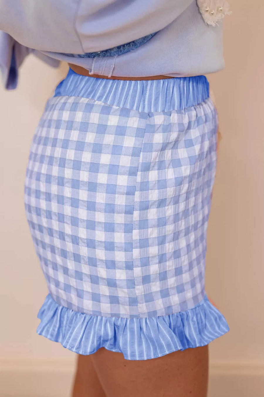 Light blue gingham cotton shorts with drawstring waist and ruffle hem.