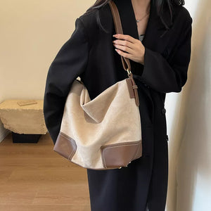 Khaki suede tote bag with brown leather accents and contrast stitching.