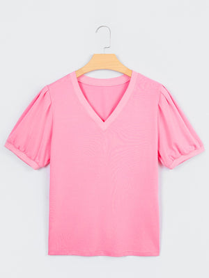 Pink cotton v-neck blouse with short puff sleeves and a relaxed fit.
