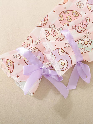 Toddler pajama set with egg print, pink gingham, and lavender ribbon bows on sleeves.