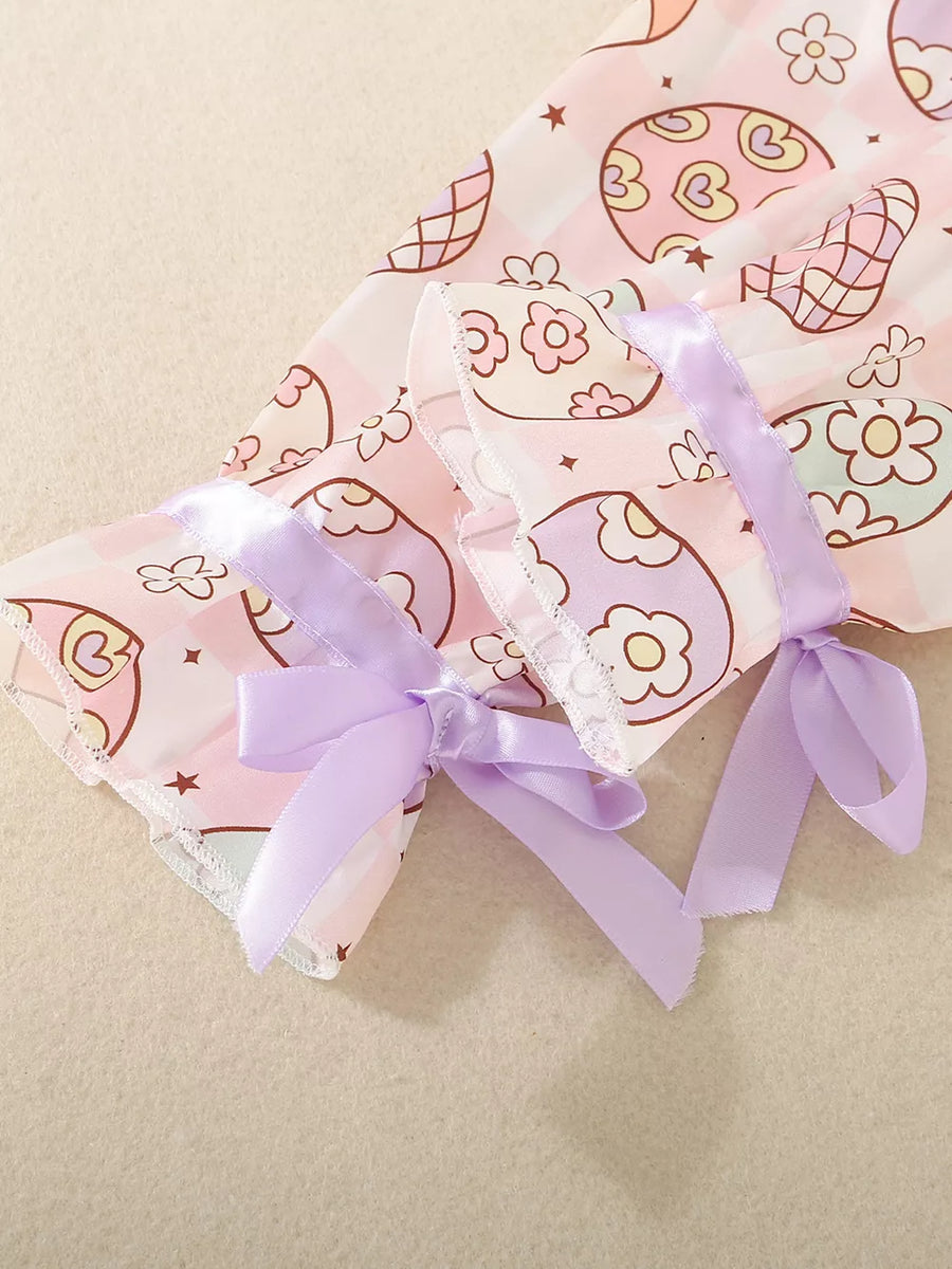 Toddler pajama set with egg print, pink gingham, and lavender ribbon bows on sleeves.