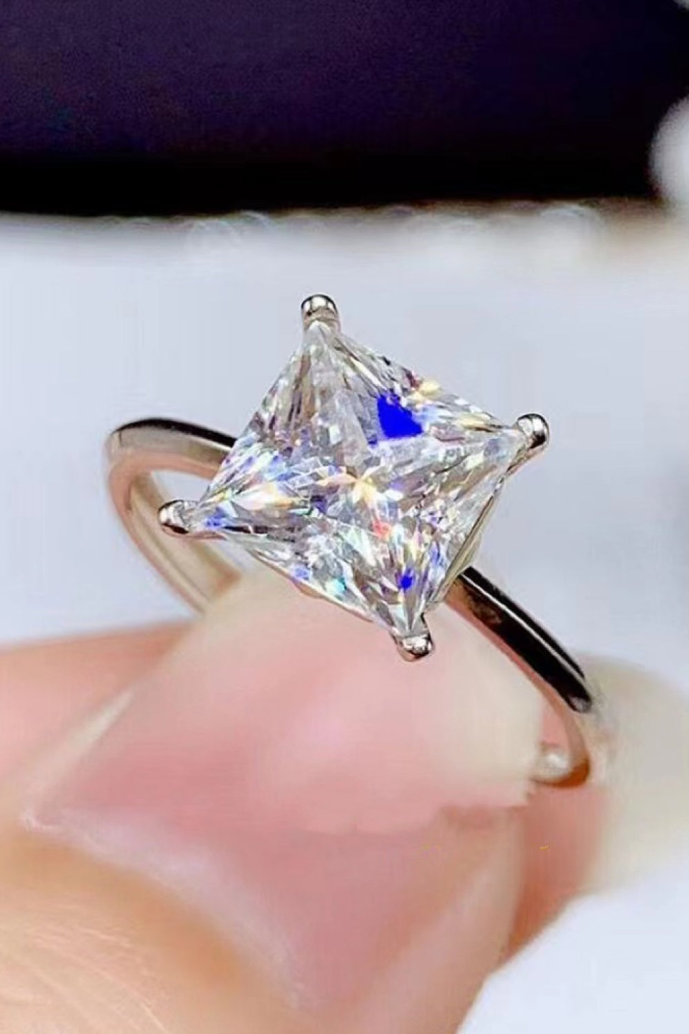 Silver ring with a bright, square-cut solitaire diamond.