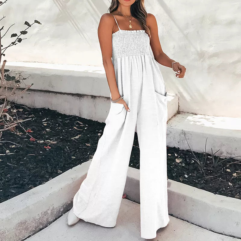 White smocked wide leg romper with spaghetti straps and side pockets.