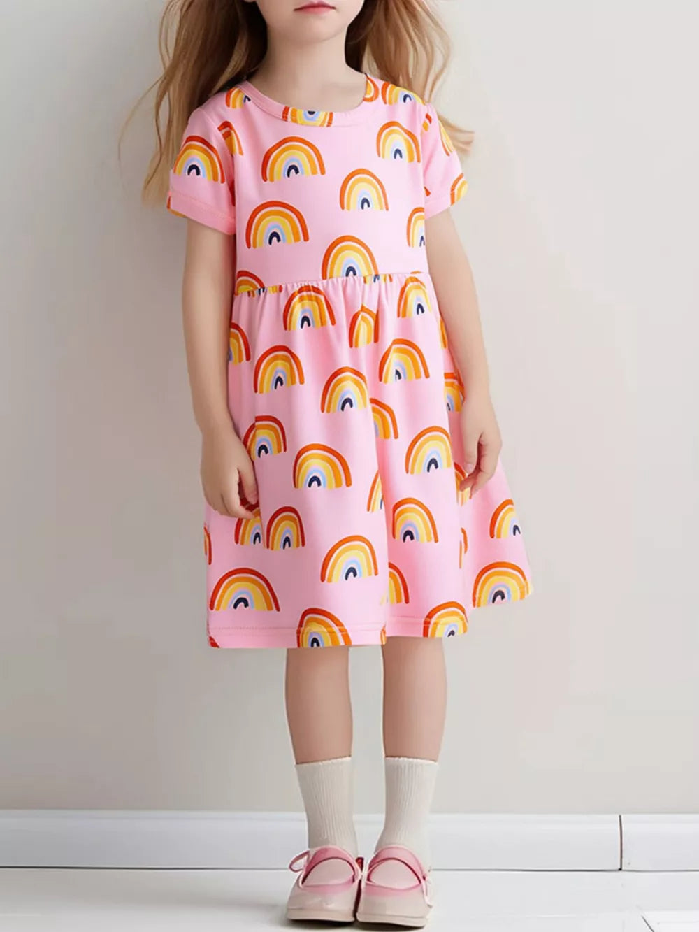Toddler pink cotton blend dress with rainbow print, short sleeves, and tiered skirt.