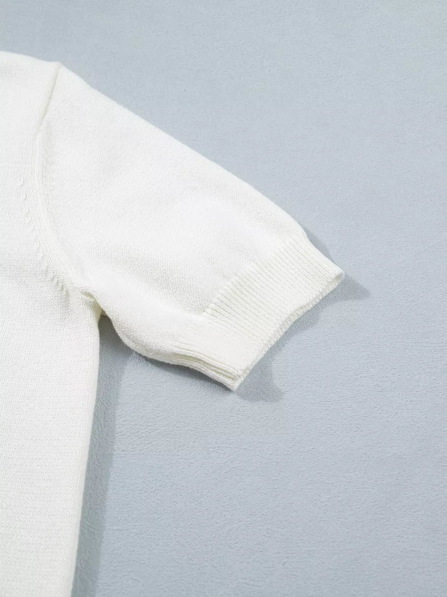 White short-sleeve sweater with ribbed cuffs and hem, made of acrylic and cotton blend.