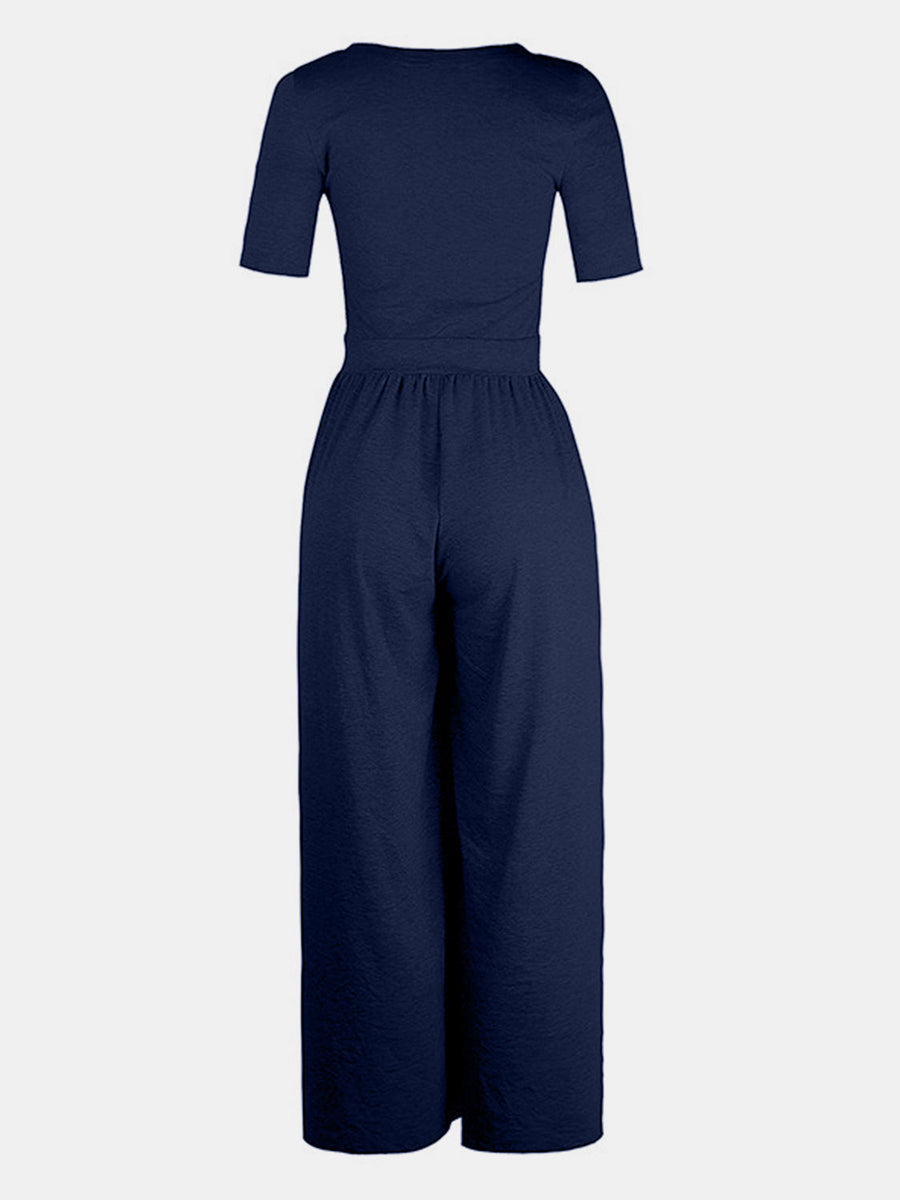 Dark blue textured wide-leg maternity jumpsuit with short sleeves and elastic waist