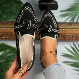 Black chain-stitched knit bow pointed flats with white trim and a bow detail.
